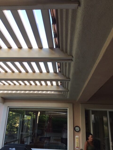 A patio cover with blinds on top of it