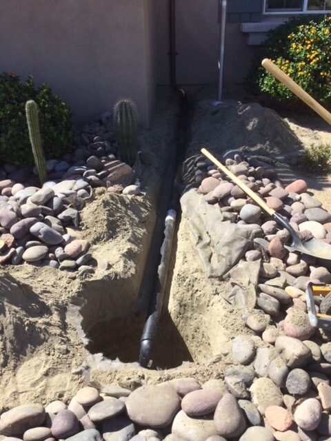 This is 1 of 5 shots of how I install an underground drain from a downspout / first the ditch is dug to fit the pipe and a hole is dug / size of the hole will depend on how much water will run into it.