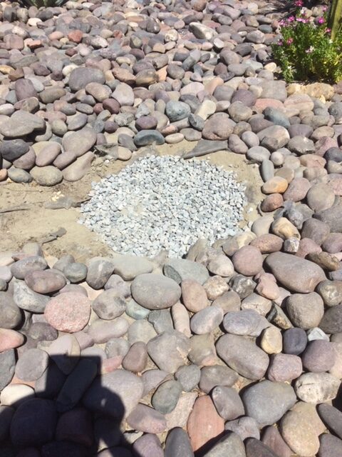 A pile of rocks on the ground with a hole in it.
